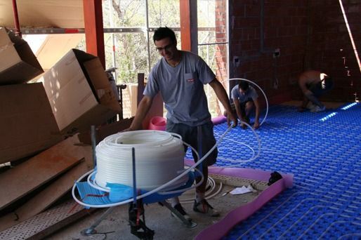 Un hombre lleva un rollo grande de tubería en un carro.