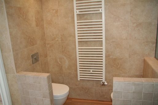 Un baño con inodoro y toallero.