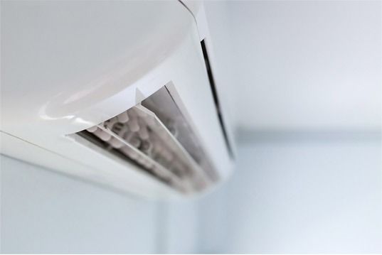 Un acondicionador de aire blanco está colgado en una pared blanca.