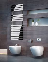 Un baño con dos inodoros, un bidé y un toallero.