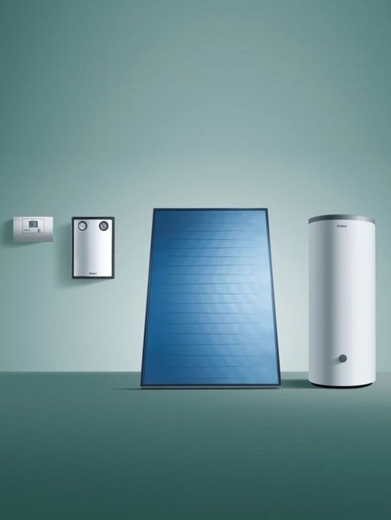 Un panel solar azul está junto a un calentador de agua blanco.