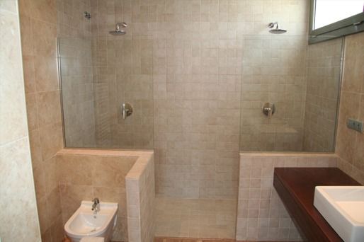 Un baño con dos duchas y un lavabo.