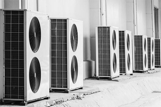 Una fotografía en blanco y negro de una fila de acondicionadores de aire.
