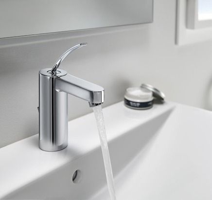 Un lavabo de baño con un grifo y agua saliendo de él.