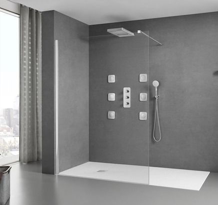 Un baño con ducha a ras de suelo y ventana.