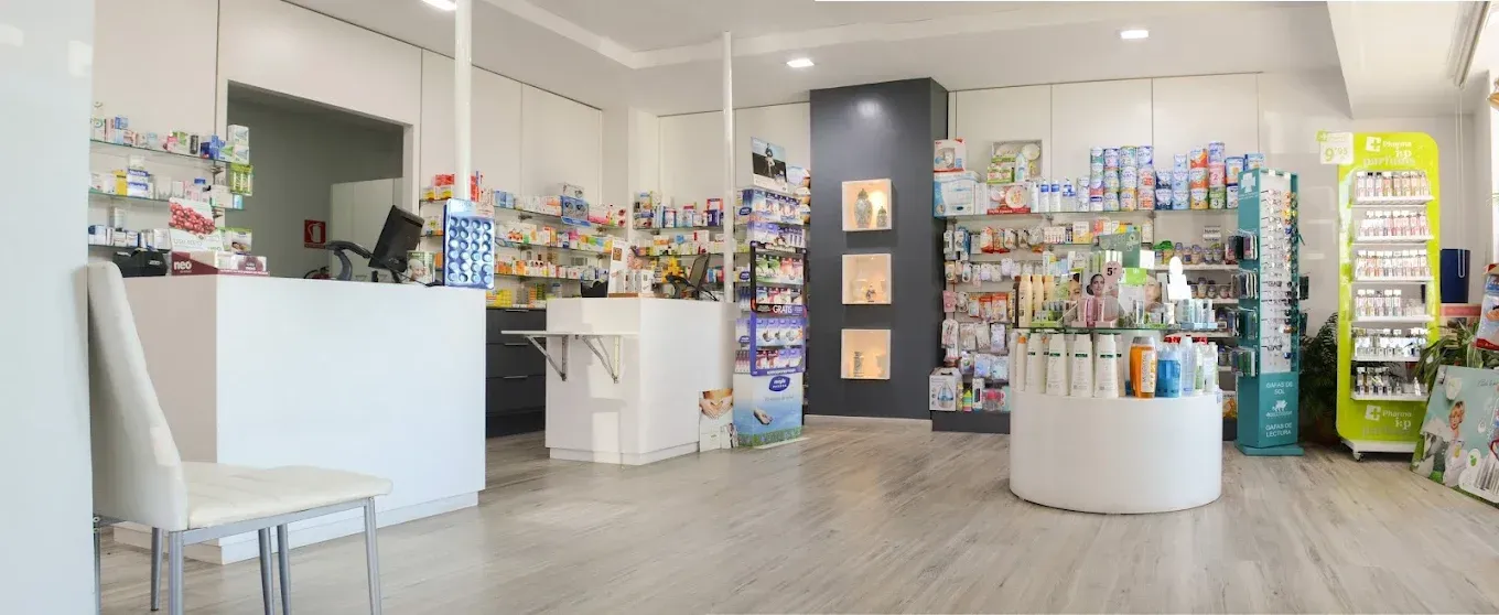 Interior luminoso de farmacia o tienda de regalos con mostradores, estantes y expositores.