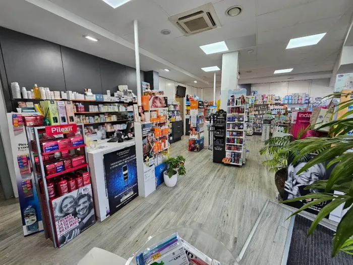 Interior de la tienda con estanterías llenas de productos coloridos, una caja registradora 