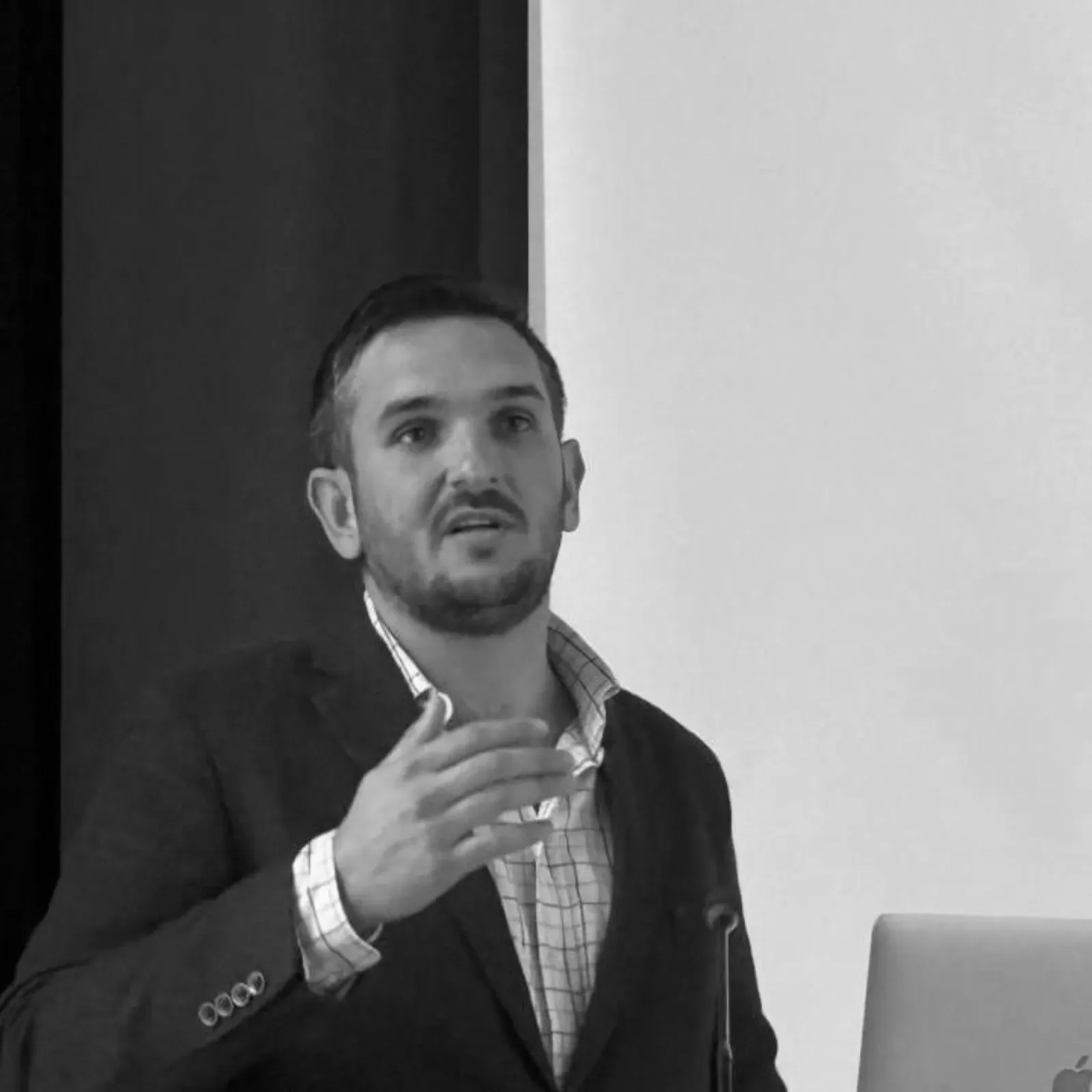 Un hombre con barba lleva traje y corbata.