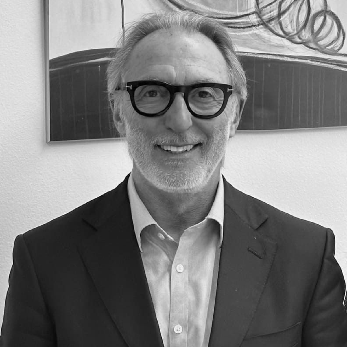 Un hombre con barba lleva traje y corbata.