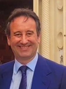 Un hombre con cabello oscuro está sonriendo en un círculo.