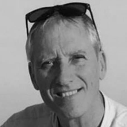 Un hombre con barba lleva traje y corbata.