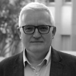 Un hombre con barba lleva traje y corbata.