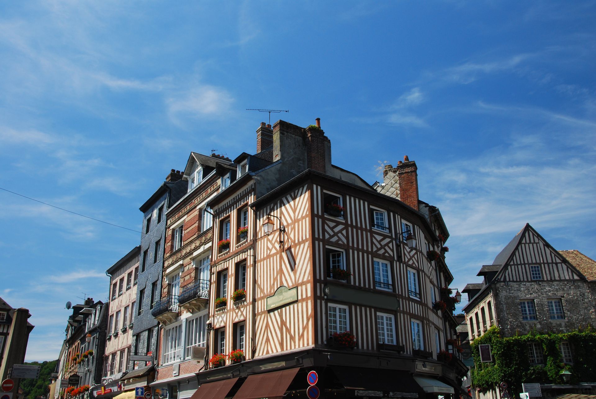 Des immeubles à plusieurs étages avec des façades à colombages se détachant sur un ciel bleu.