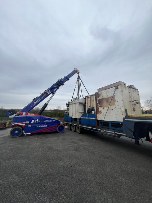 Une grue électrique bleu soulève une machine