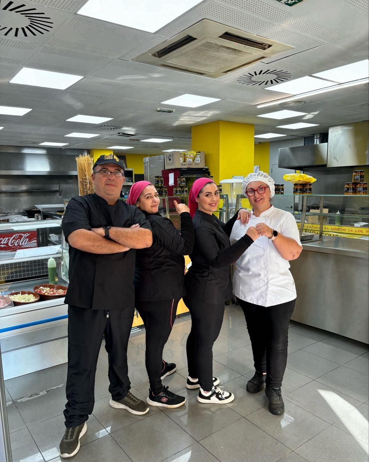 Un grupo de personas posa para una fotografía en una cocina.