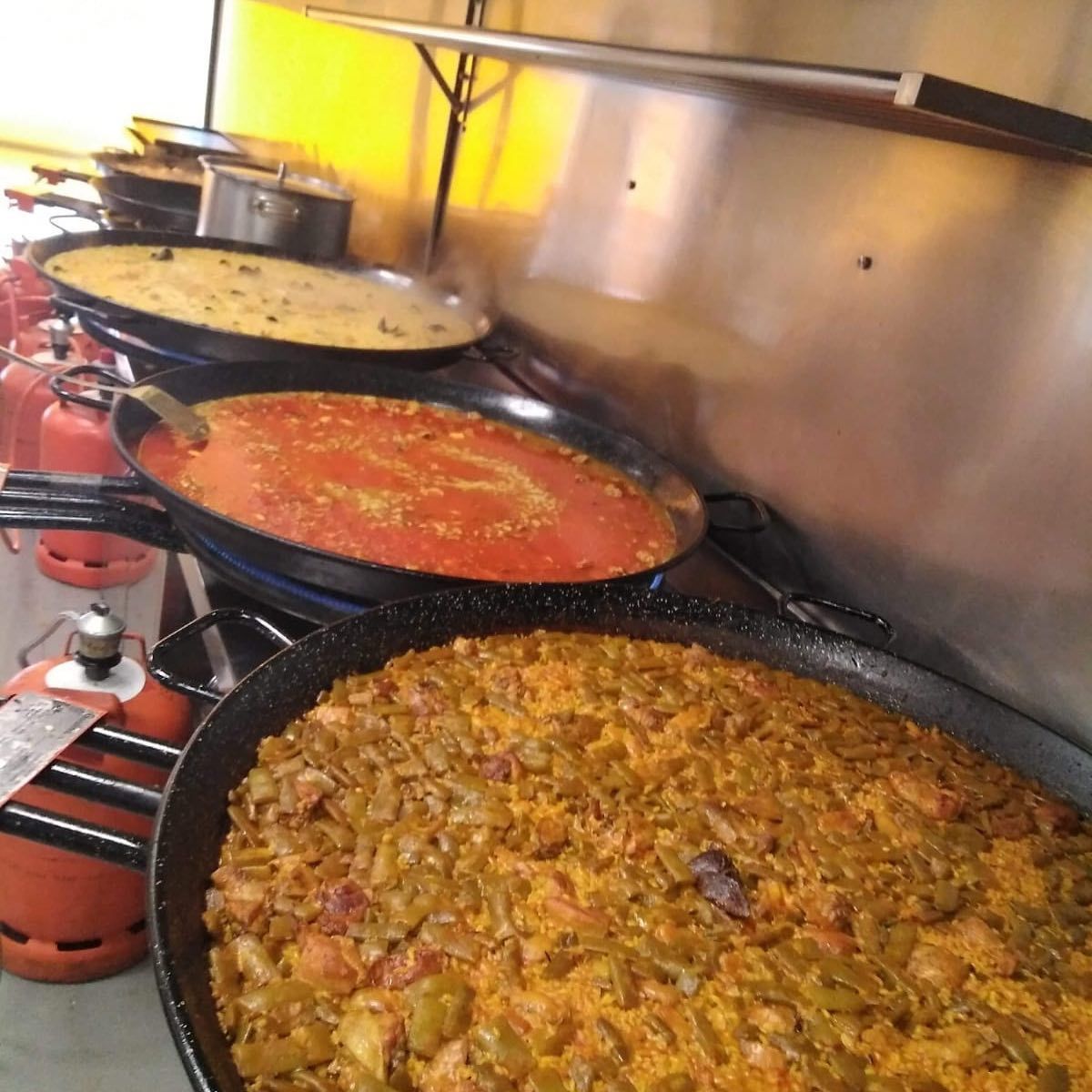 Una fila de sartenes llenas de diferentes tipos de alimentos