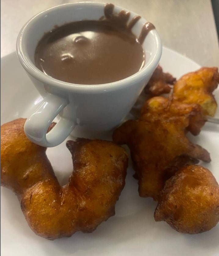 Un plato de comida con una taza de salsa de chocolate