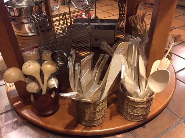 Una exposición de utensilios de madera sobre una mesa de madera.