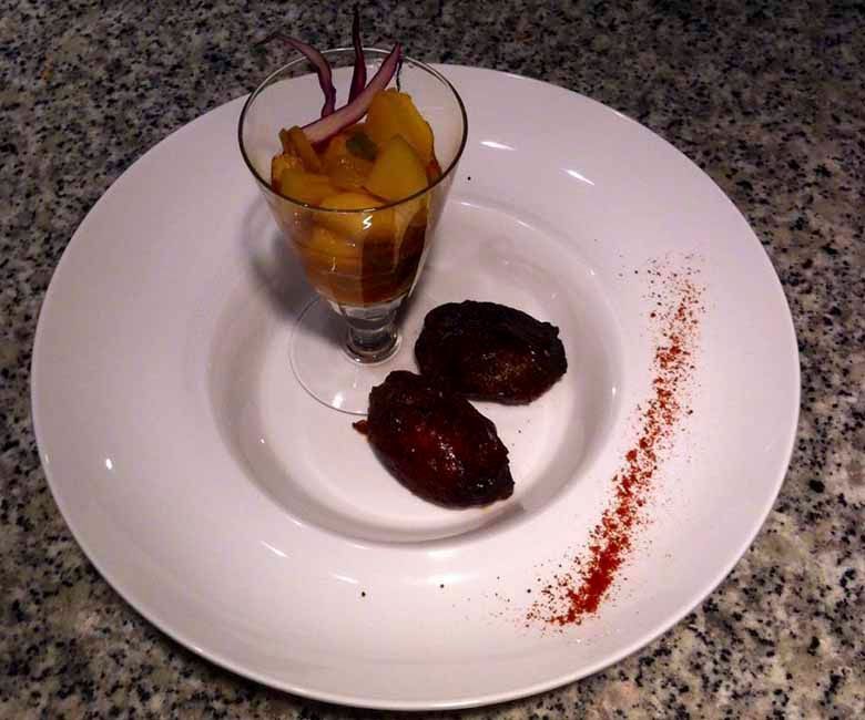 Un plato blanco con un vaso de comida encima.