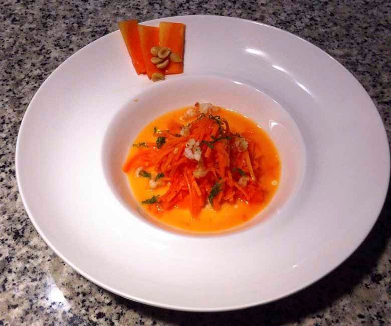 Un plato blanco cubierto con zanahorias y salsa.