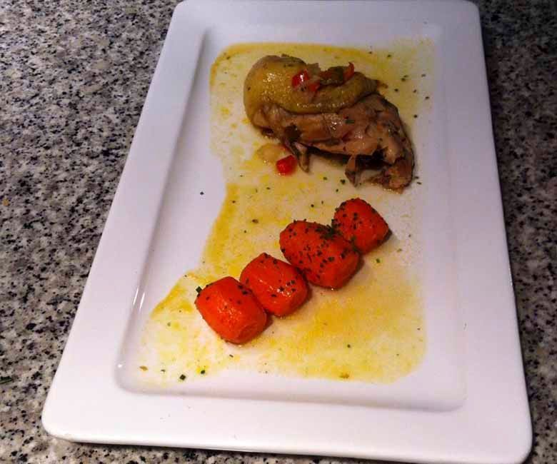 Un plato blanco con carne y zanahorias encima.