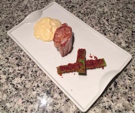 Un plato blanco cubierto con carne y puré de papas sobre una encimera de granito.