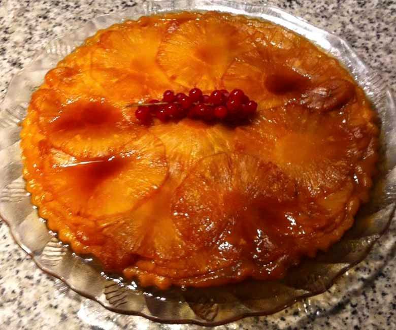 Un pastel de piña al revés con grosellas rojas encima
