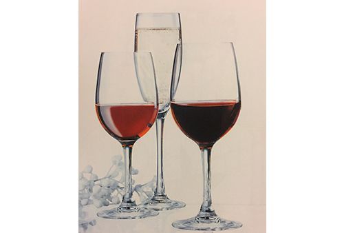 Tres copas de vino llenas de diferentes tipos de vino en una mesa.