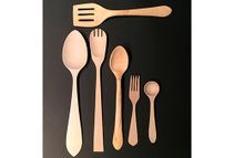 Un grupo de cucharas, tenedores y espátulas de madera sobre una superficie negra.