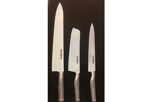 Tres cuchillos de diferentes tamaños están alineados sobre una superficie negra.