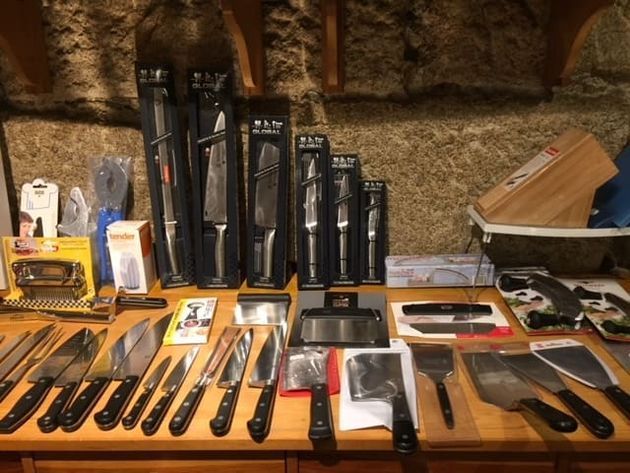 Un montón de cuchillos están alineados sobre una mesa.