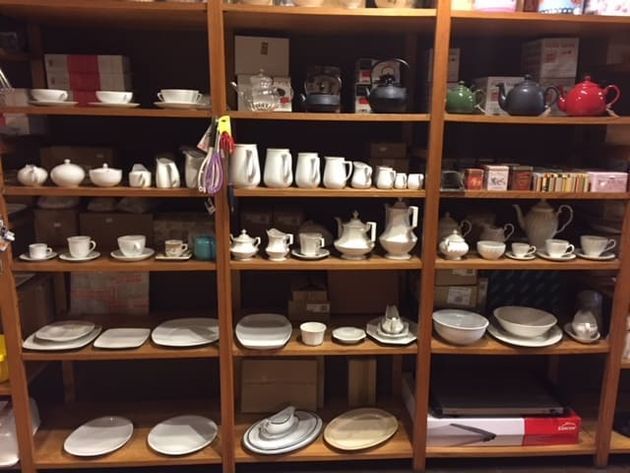 Un estante lleno de una variedad de platos y teteras.