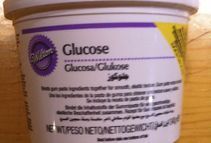 Un frasco de glucosa está sobre una mesa de madera.