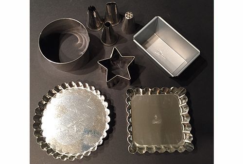 Un montón de platos y sartenes de plata sobre una mesa.