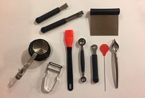 Un montón de utensilios de cocina están sobre una mesa.