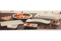 Hay muchos tipos diferentes de platos y cuencos en la mesa.