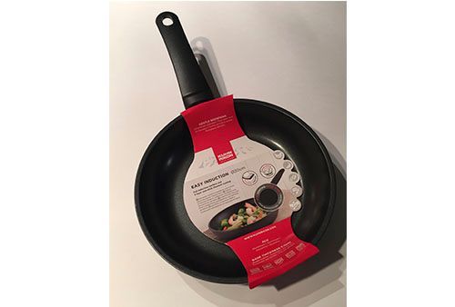 Una sartén está sobre una mesa blanca.