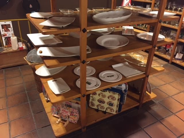 Un estante de madera lleno de platos y cuencos.