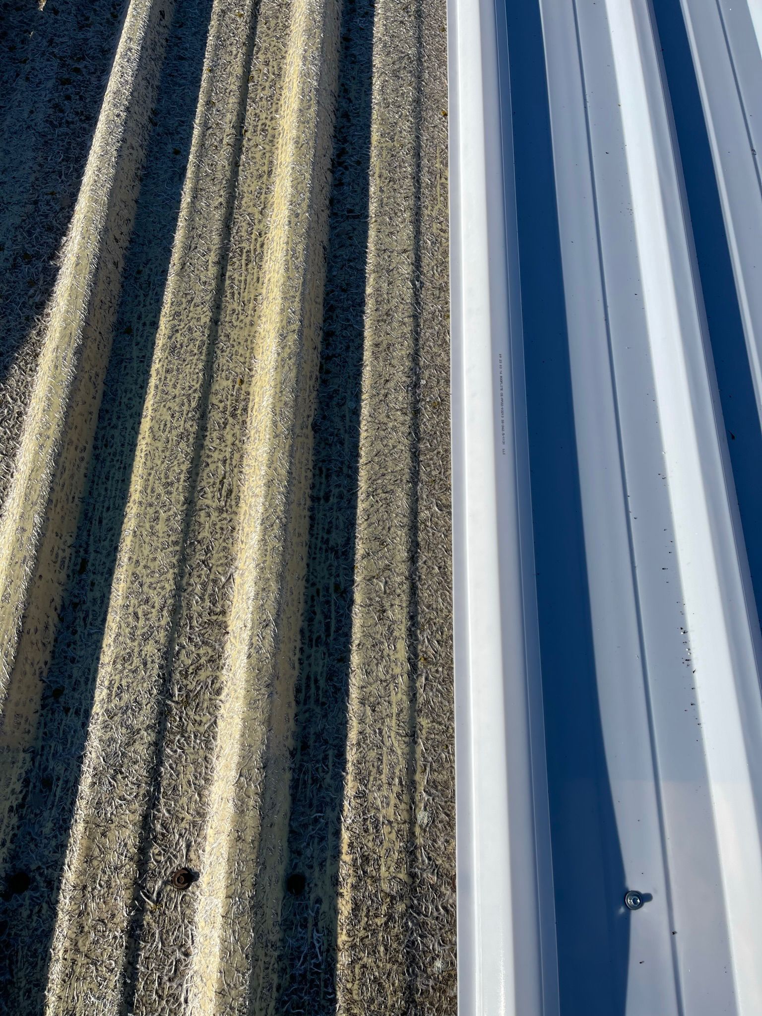Un primer plano de un techo de metal con un cielo azul de fondo.