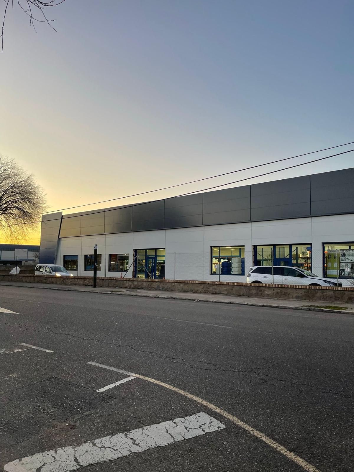 Un gran edificio con muchas ventanas está al lado de un estacionamiento.