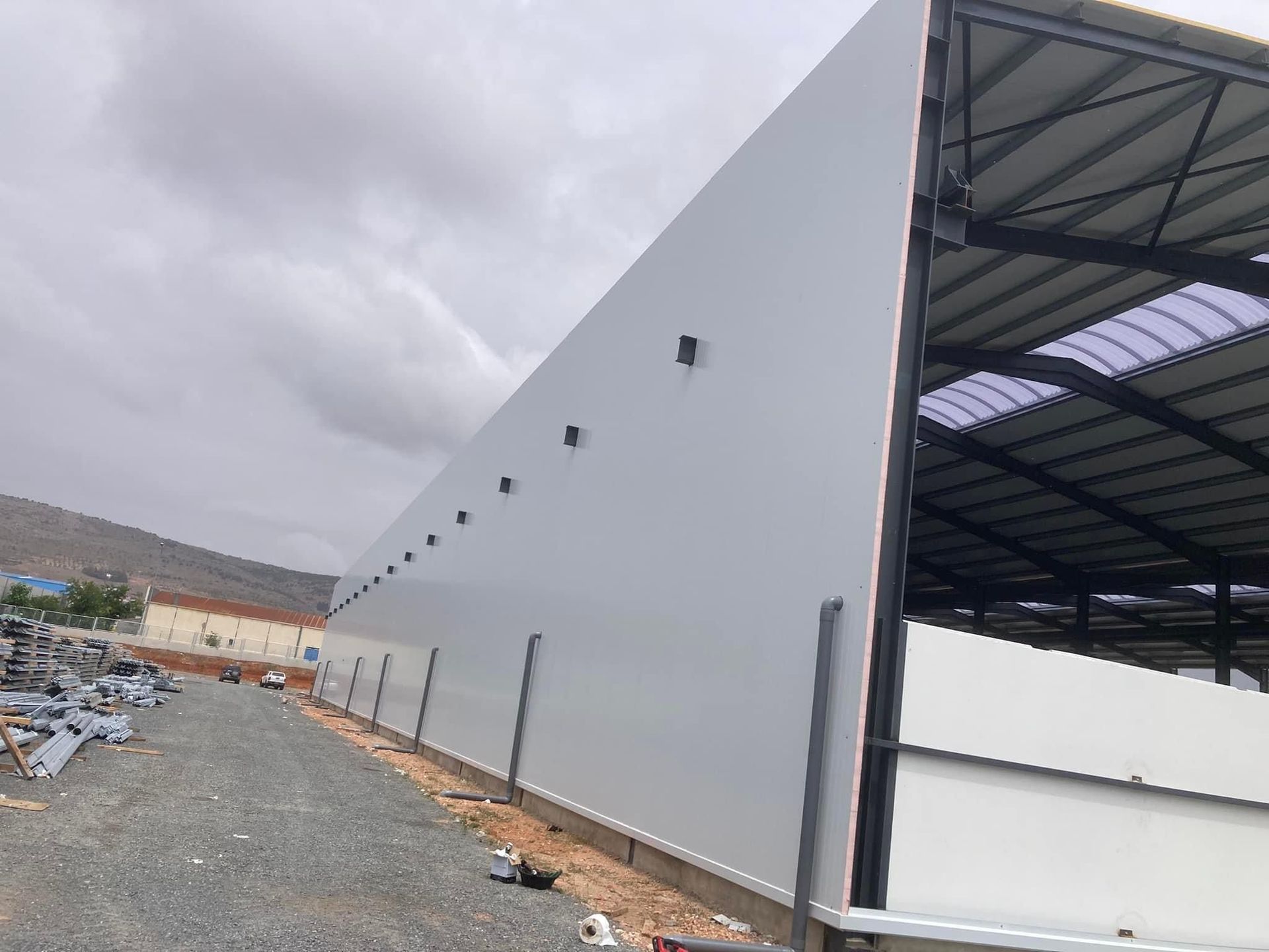Un gran edificio blanco con techo está en construcción.