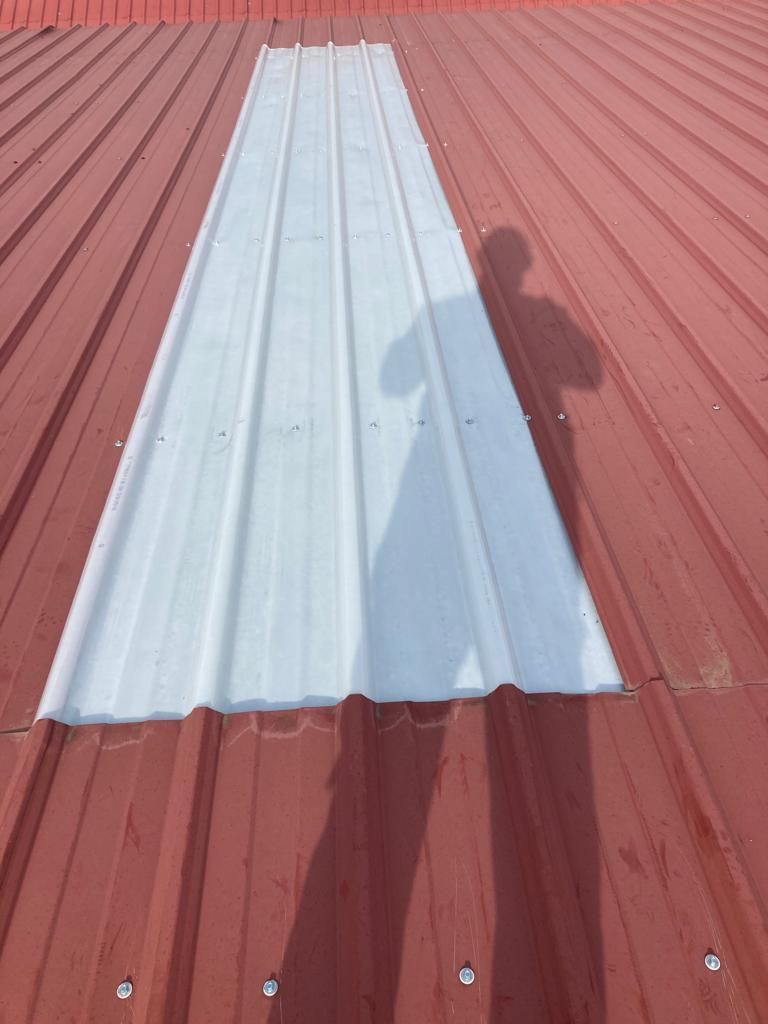 Un techo rojo con una lámina de metal blanca encima.