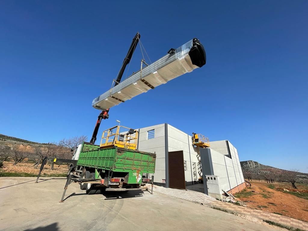 Una grúa está levantando un gran trozo de hormigón en el aire.