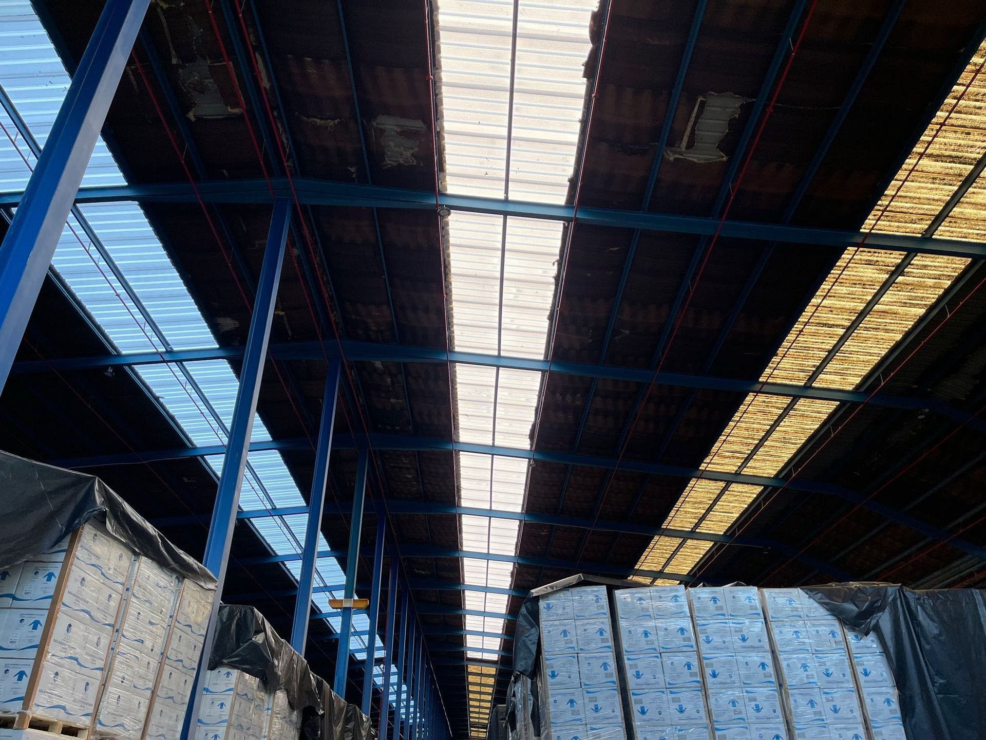 Un almacén lleno de muchas cajas y con un techo transparente.