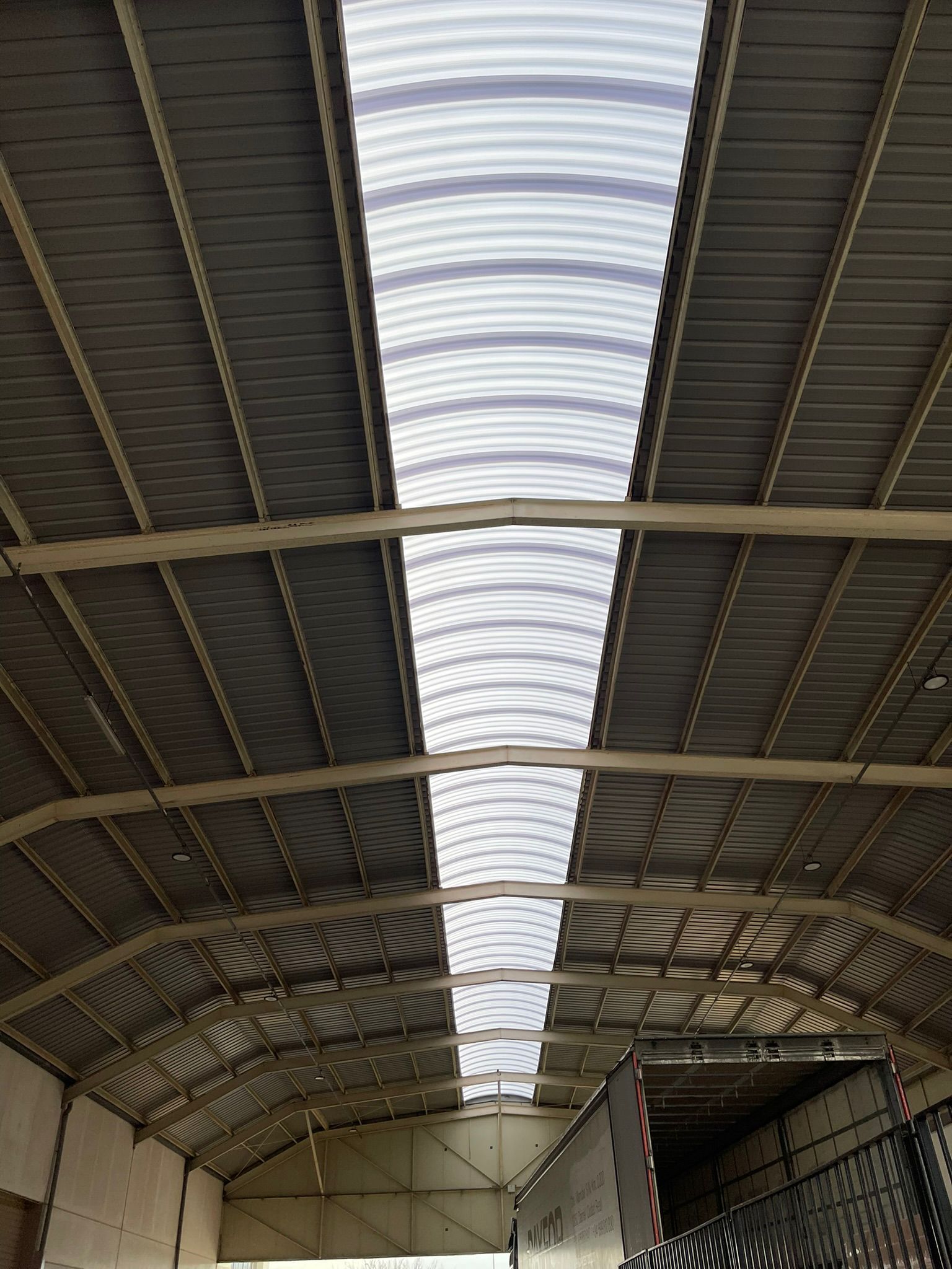 Un gran almacén con techo transparente y muchas ventanas.