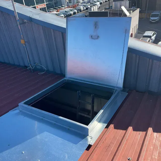 Un techo con una trampilla metálica que se abre