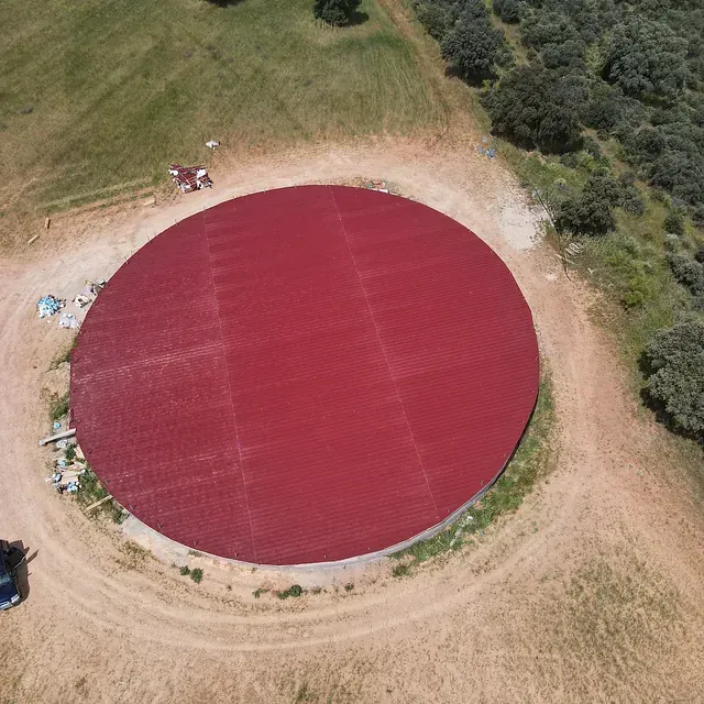 Una vista aérea de un gran círculo rojo en el medio de un campo.