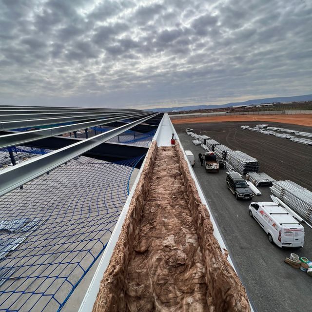 Una fila de furgonetas blancas están estacionadas al costado de una carretera