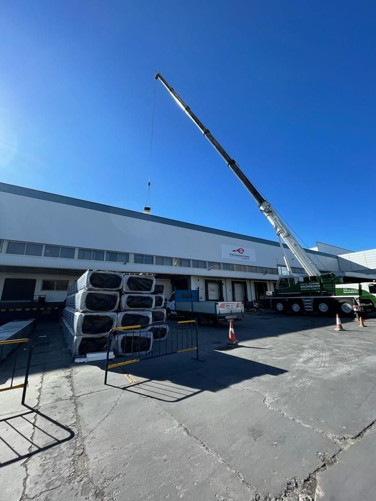 Una gran grúa está sentada frente a un gran edificio.