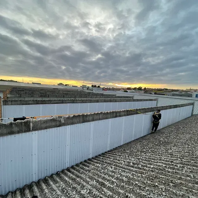 Un hombre está de pie en el tejado de un edificio.